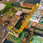 Home Aerial view of a bustling industrial dock with cranes and ships in Jakarta, Indonesia.